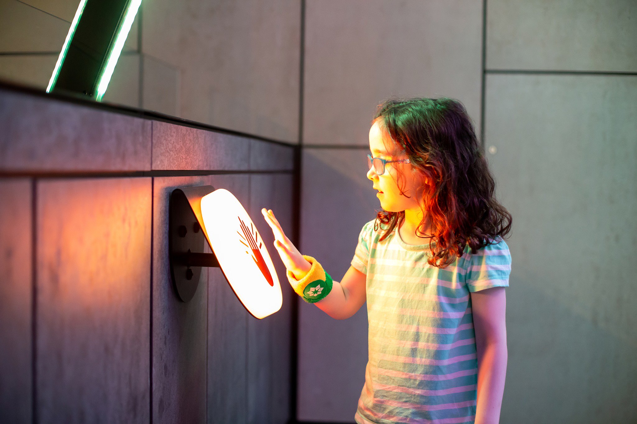 Visitor tapping wearable band at an exhibit