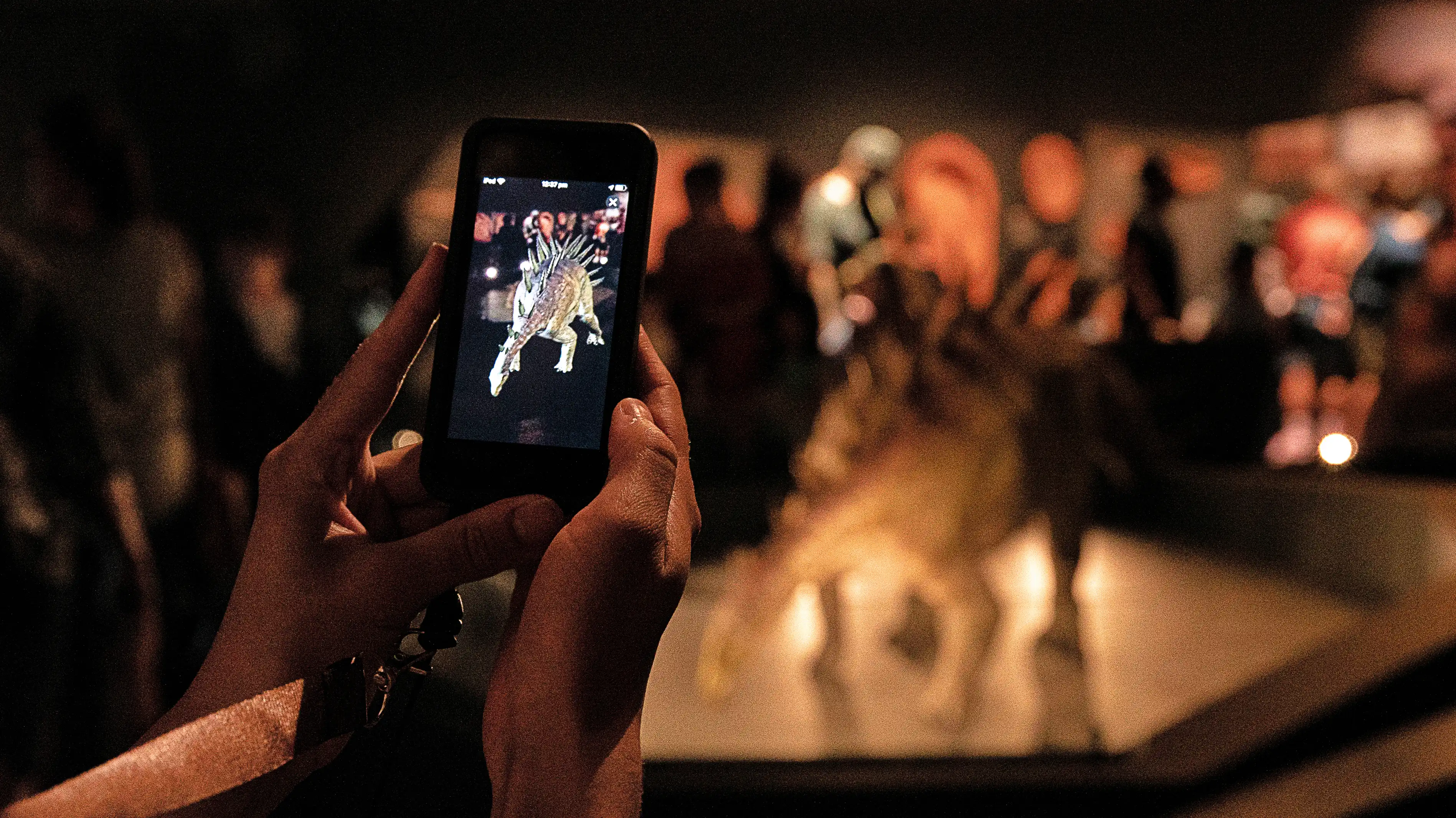 Child viewing an augmented reality dinosaur reconstruction at WA Museum Boola Bardip